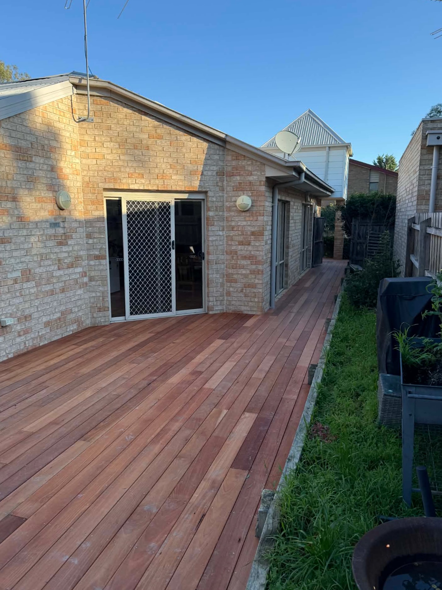 Karri deck laid level with the back door threshold, running down the side of the house with no step